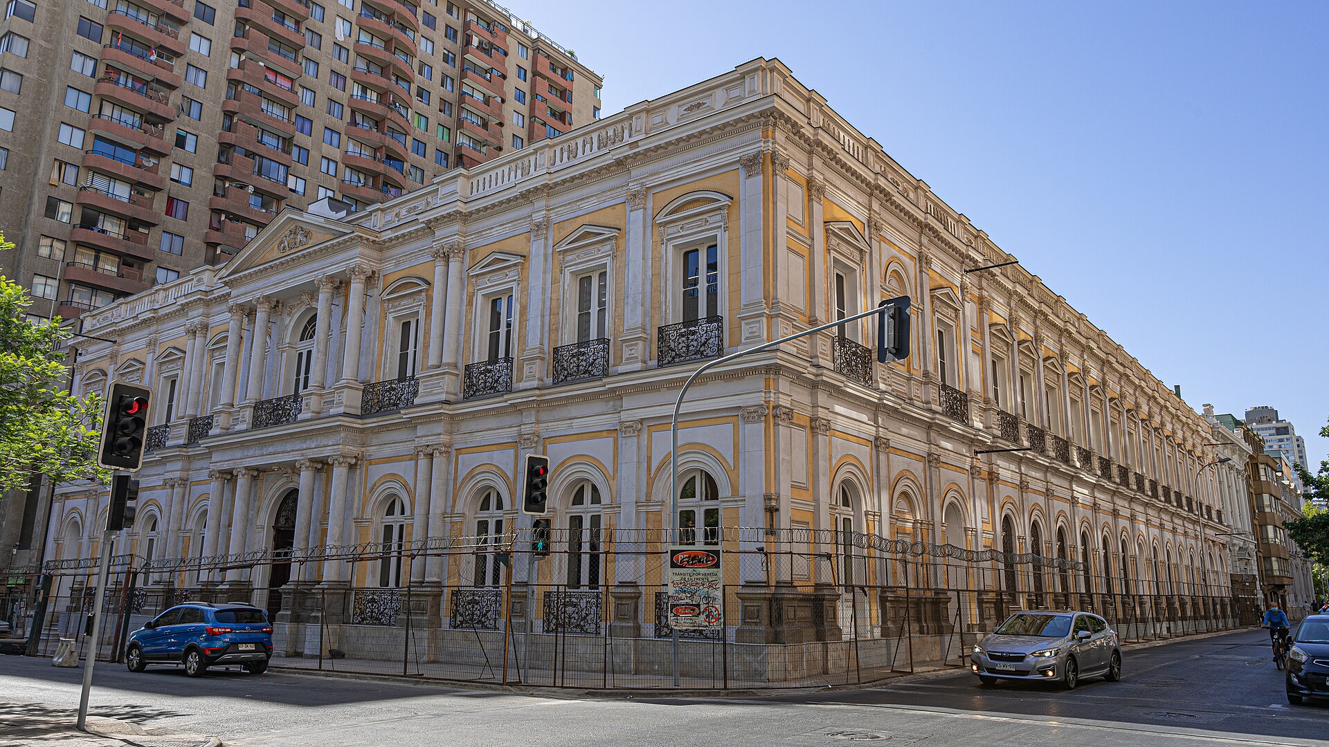 Ornate neoclassical building beside a modern apartment tower on a city street in Santiago, Chile